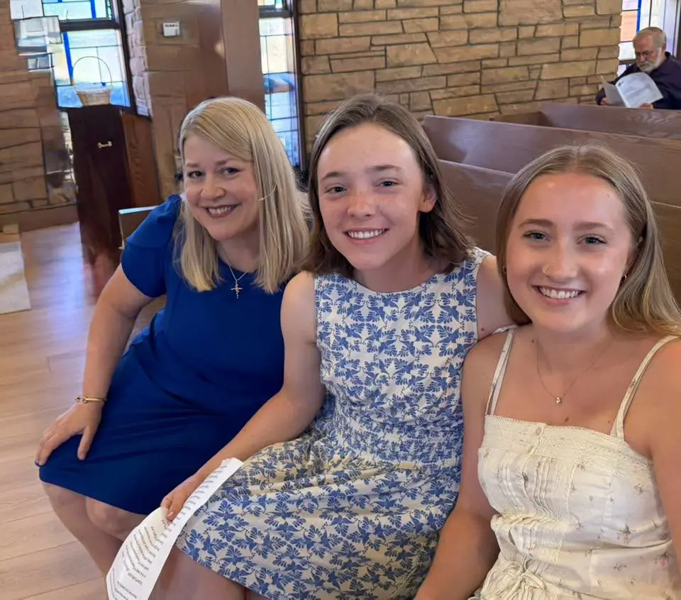 A parent and two teenagers seated together in the Sanctuary, Sunday bulletin in hand.