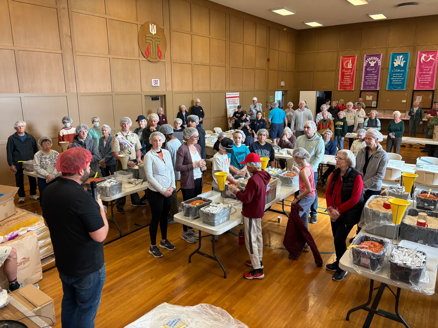 PCLG volunteers working across Fellowship Hall during a Rise Against Hunger packing event.