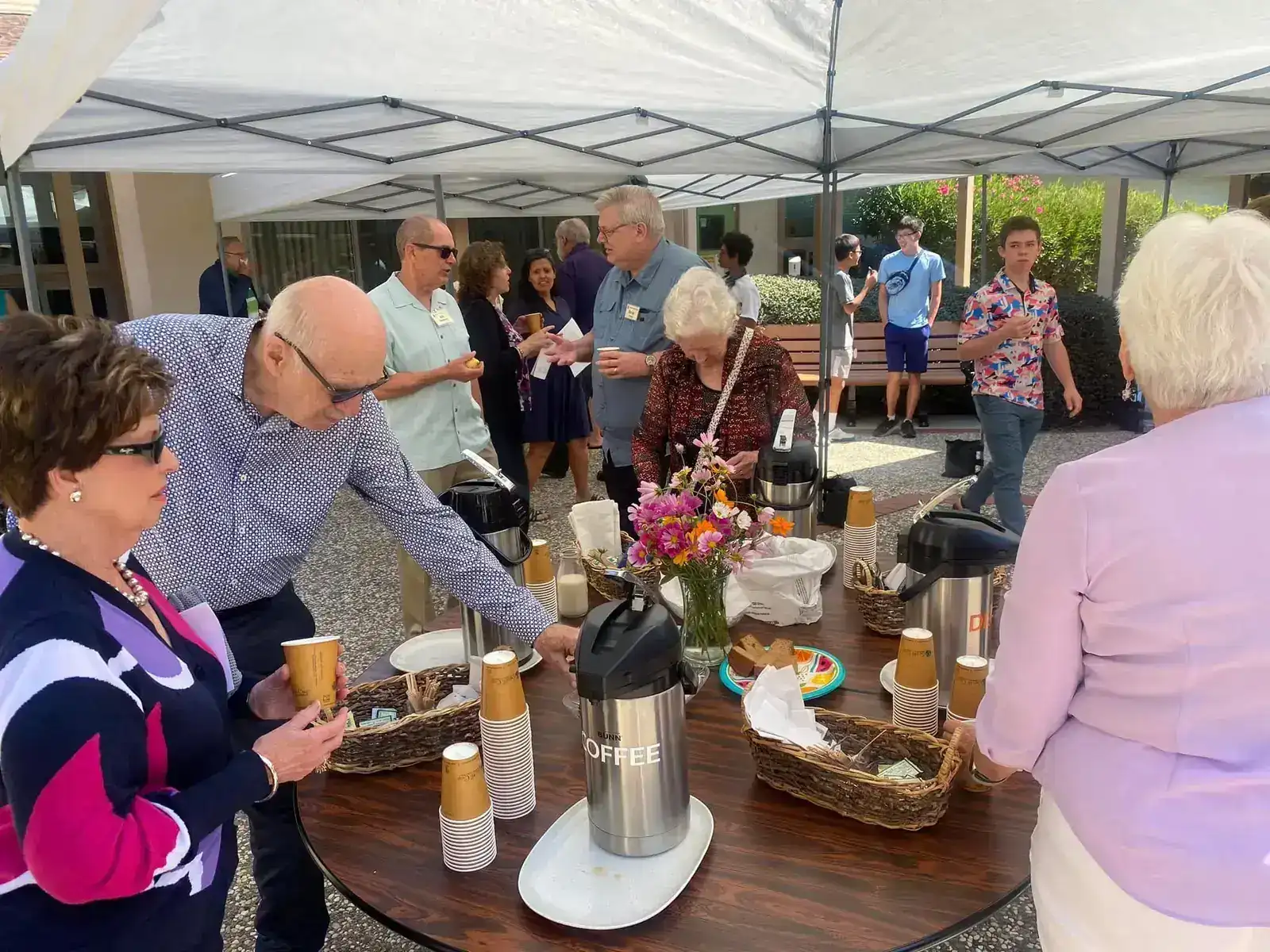 PCLG members pouring coffee together in the courtyard after worship.