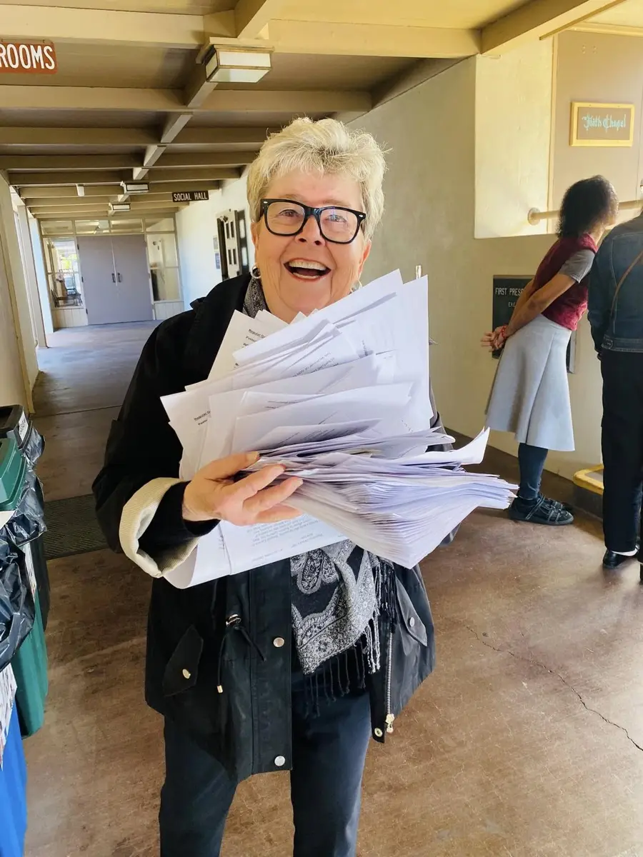 A PCLG volunteer collecting worship bulletins after the service.